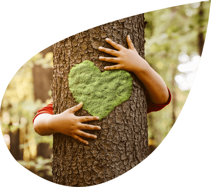 Kind umarmt einen Baum mit einem herzförmigen Moosbewuchs als Symbol für nachhaltige Materialnutzung und Umweltbewusstsein.